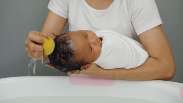 Moeder Wassen Pasgeboren Baby Haar Met Spons Een Bad — Stockvideo