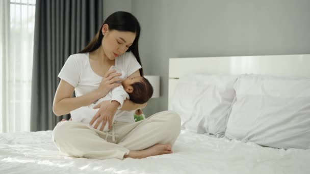 Mor Mata Mjölkflaska Till Sitt Nyfödda Barn Säng — Stockvideo