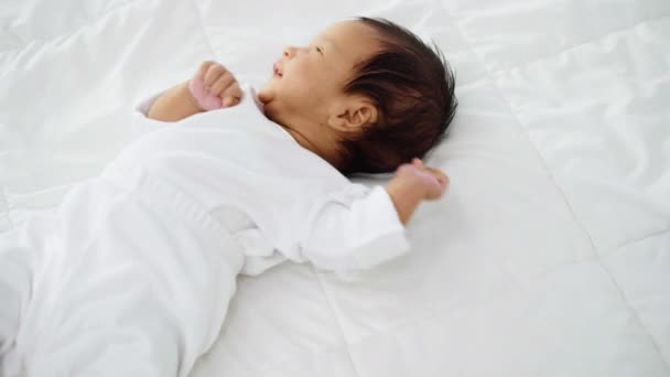 Glückliches Neugeborenes Liegt Und Spielt Auf Einem Bett — Stockvideo