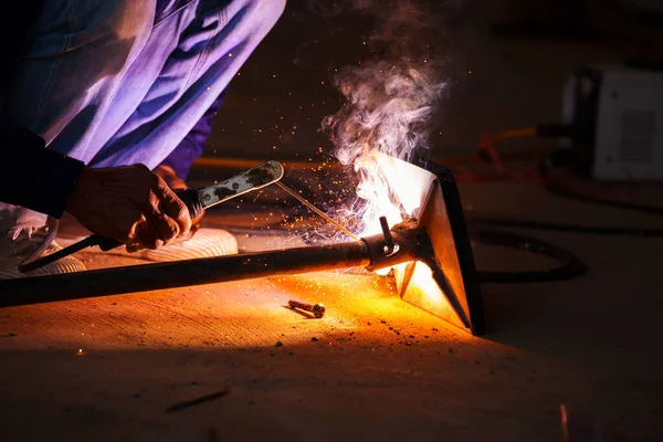 welder working with welding on metal frame with sparking light