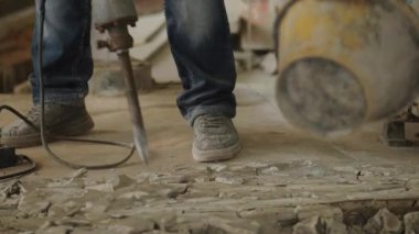 labor using a jackhammer to break up a concrete floor