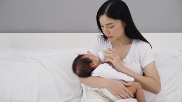 Μητέρα Ταΐζει Μπουκάλι Γάλα Στο Νεογέννητο Μωρό Της Ένα Κρεβάτι — Αρχείο Βίντεο
