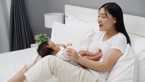 Μητέρα Κρατώντας Νεογέννητο Μωρό Της Και Παίζοντας Ένα Κρεβάτι — Αρχείο Βίντεο