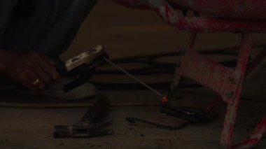 Metal çerçevede kaynak yapan kaynakçı kıvılcım saçıyor.