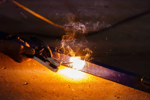 welder working with welding on metal frame with sparking light