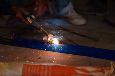 welder working with welding on metal frame with sparking light