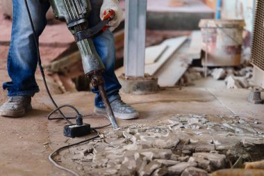 labor using a jackhammer to break up a concrete floor