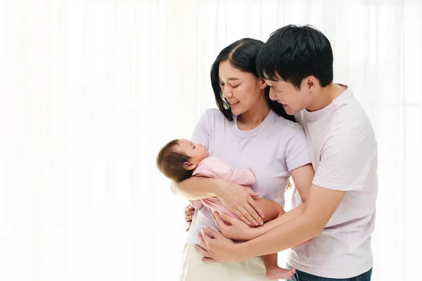 快乐的父母抱着新生儿 抱着新生儿 抱在白窗的背景下 幸福家庭概念 — 图库照片
