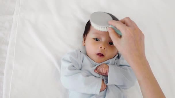 Matka Česání Její Novorozené Dítě Vlasy Posteli — Stock video