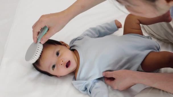 Matka Česání Její Novorozené Dítě Vlasy Posteli — Stock video
