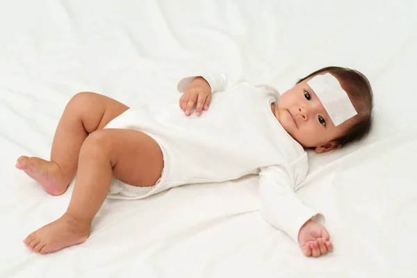 冷え性熱ジェルパッドを額に持つ病気の幼児 — ストック写真