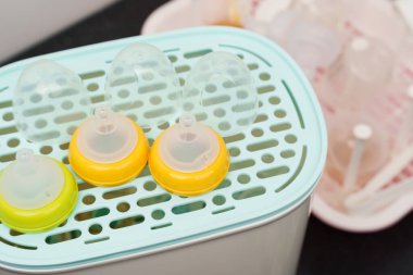 Buhar sterilizatörünün üzerindeki süt şişesinin plastik meme ucu.