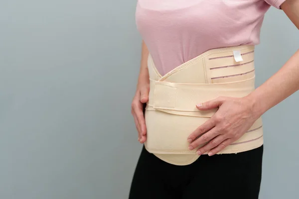 stock image woman wearing lumbar support belts. pregnant and postnatal lumbar brace after surgery