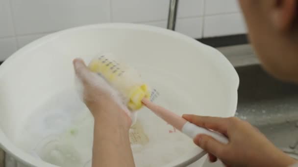 Mutter Wäscht Die Plastikmilchflasche Des Babys — Stockvideo