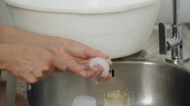 Anne eli bebeği yıkıyor plastik meme ucu süt şişesi.