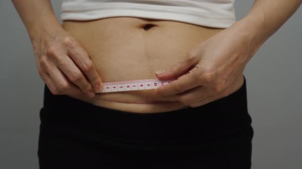 女人用胶带测量腹部剖宫产的疤痕 — 图库视频影像