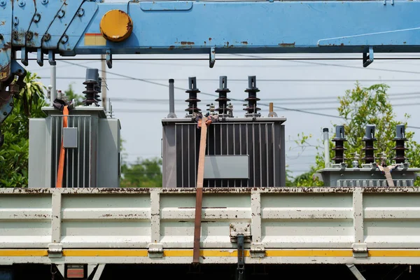 power transformer strapped on a truck and crane arm