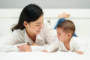 Anne ve bebek bir yatakta ağlıyor.