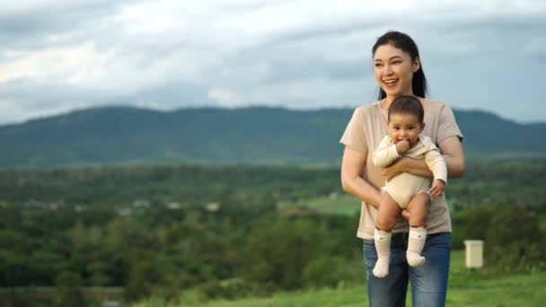 Cámara Lenta Madre Feliz Sosteniendo Bebé Caminando Montaña Verde — Vídeos de Stock