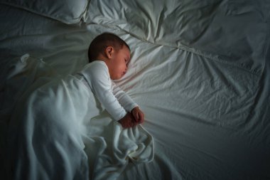 Bebek gece yatakta uyuyor.