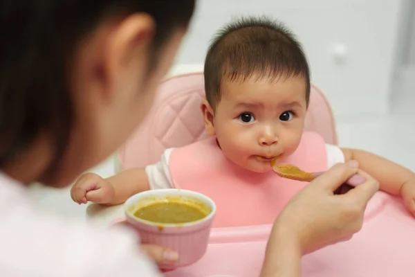 母亲在家里用勺子喂婴儿吃东西 — 图库照片