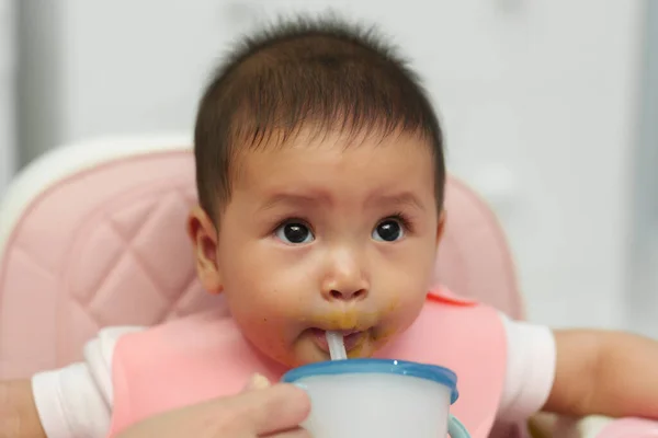 幼い赤ちゃんは母親の餌で藁で水を飲んで — ストック写真