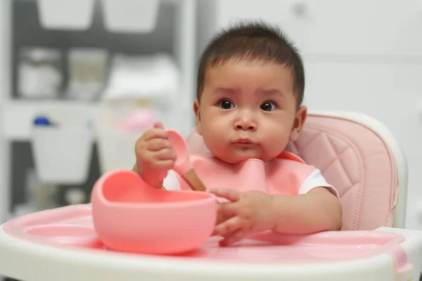 幸せな赤ちゃんは家でスプーンで食べ物を食べる — ストック写真