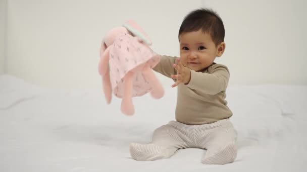 Baby Spielt Puppe Auf Einem Bett — Stockvideo