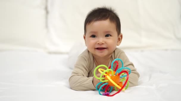 Младенец Играет Красочными Резиновыми Укусами Игрушки Кровати — стоковое видео