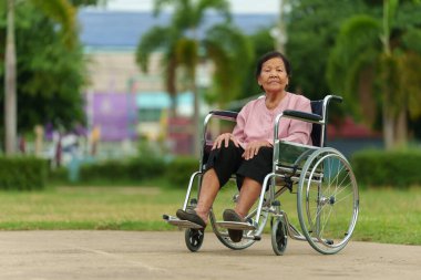 senior woman sitting in wheelchair at the park