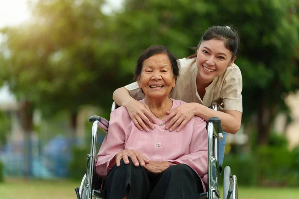 Glückliche Junge Enkelin Umarmt Seniorin Rollstuhl Park Stockbild