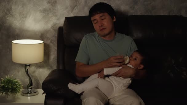 Сонный Отец Зевает Кормит Младенца Молочной Бутылкой Диване Гостиной Ночью — стоковое видео