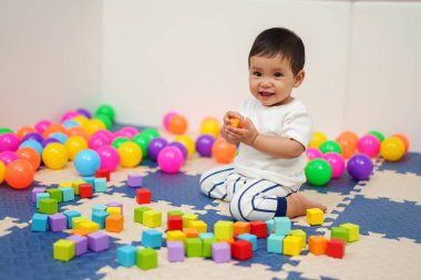 Mutlu bebek evde tahta blok oyuncağı oynuyor.