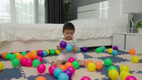 Baby Spielt Bunte Plastikbälle Auf Puzzlematte Schlafzimmer — Stockvideo