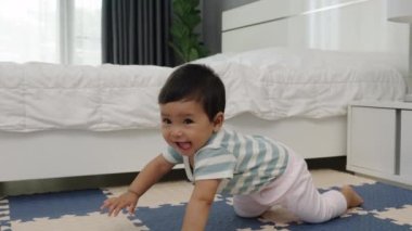 Bebek paspasın üzerinde emekliyor ya da yatak odasındaki yapboz zemininde
