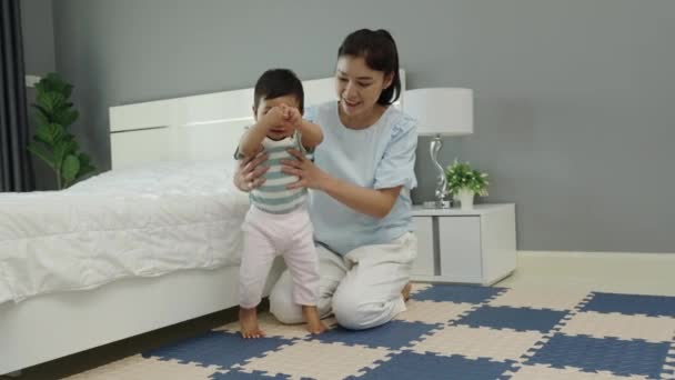 ベッドルームのマットフロアで母親と立つことを学ぶ赤ちゃん — ストック動画