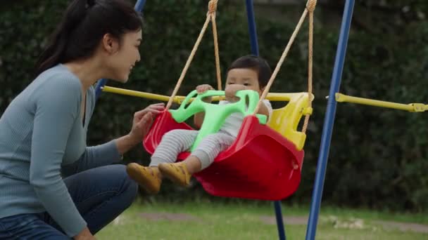 Câmera Lenta Mãe Com Bebê Infantil Está Brincando Balanço Jardim — Vídeo de Stock