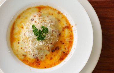 Tahta masadaki etli lazanya.