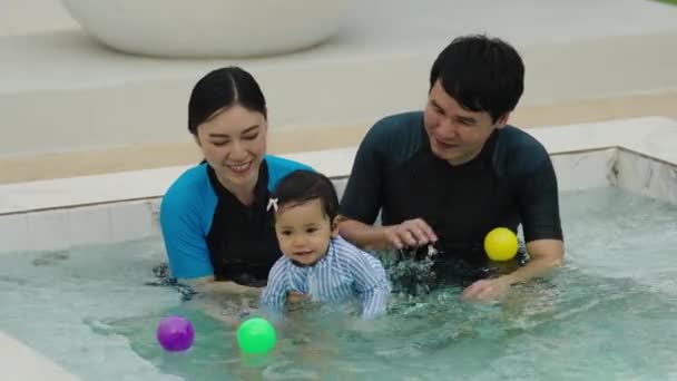 Glückliche Familie Vater Und Mutter Mit Kleiner Tochter Spielen Schwimmbad — Stockvideo