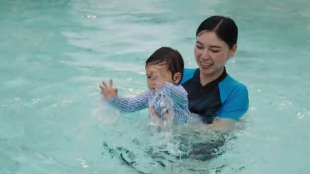 Feliz Madre Sosteniendo Bebé Sus Brazos Mientras Juega Agua Salpicando — Vídeo de stock