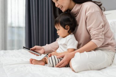 Bebekken anne yatakta akıllı telefon kullanır ve izlerdi.