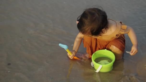Χαρούμενο Κοριτσάκι Παίζει Παιχνίδι Και Νερό Στην Παραλία Της Θάλασσας — Αρχείο Βίντεο