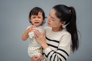 Anne kucağında ve ağlayan bebeğini teselli ediyor. 