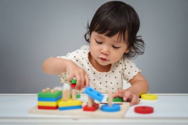 Küçük bebek masada ahşap eğitici geometrikle oynuyor.