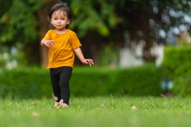 Mutlu küçük bebek parkta yürüyor.