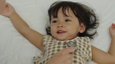 Doktor, yeni yürümeye başlayan çocuğun göğsünde steteskop kullanıyor. bebek sağlığı konsepti