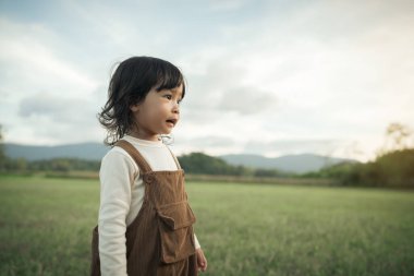 Mutlu küçük kız çim tarlasında