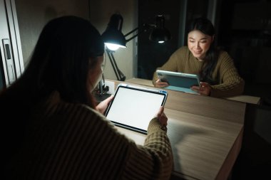 Mutlu kadın bir gecede beyaz ekranlı dijital tablet izliyor.