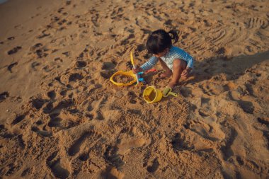 Pattaya, Tayland 'da kumsalda kumlarla oynayan mutlu bir bebek.