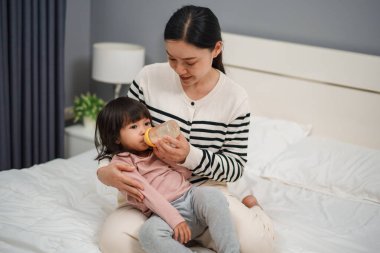 Anne, bebeği sütle besledi.